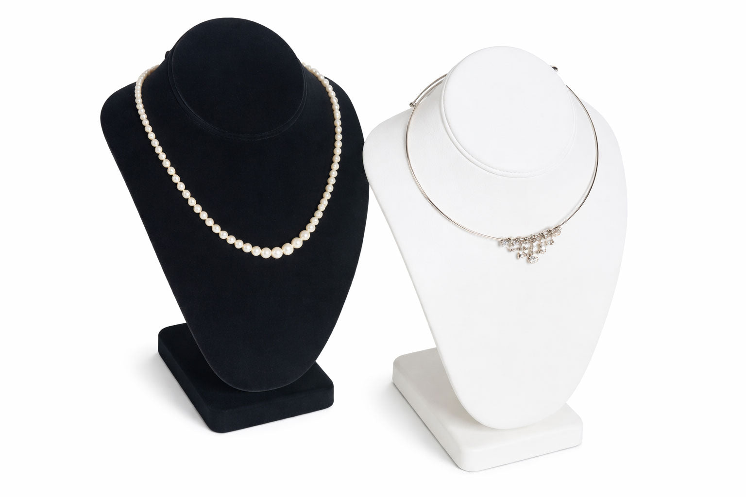 Black and white jewelry display stands with necklaces on a white background