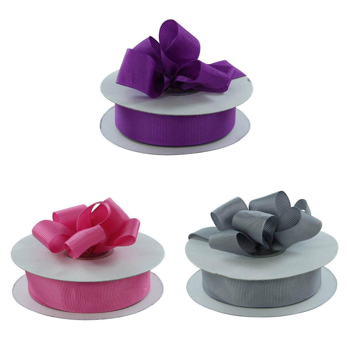 Three spools of ribbon with bows on a white background
